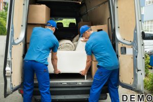 42544874 - two male workers in blue uniform adjusting sofa in truck